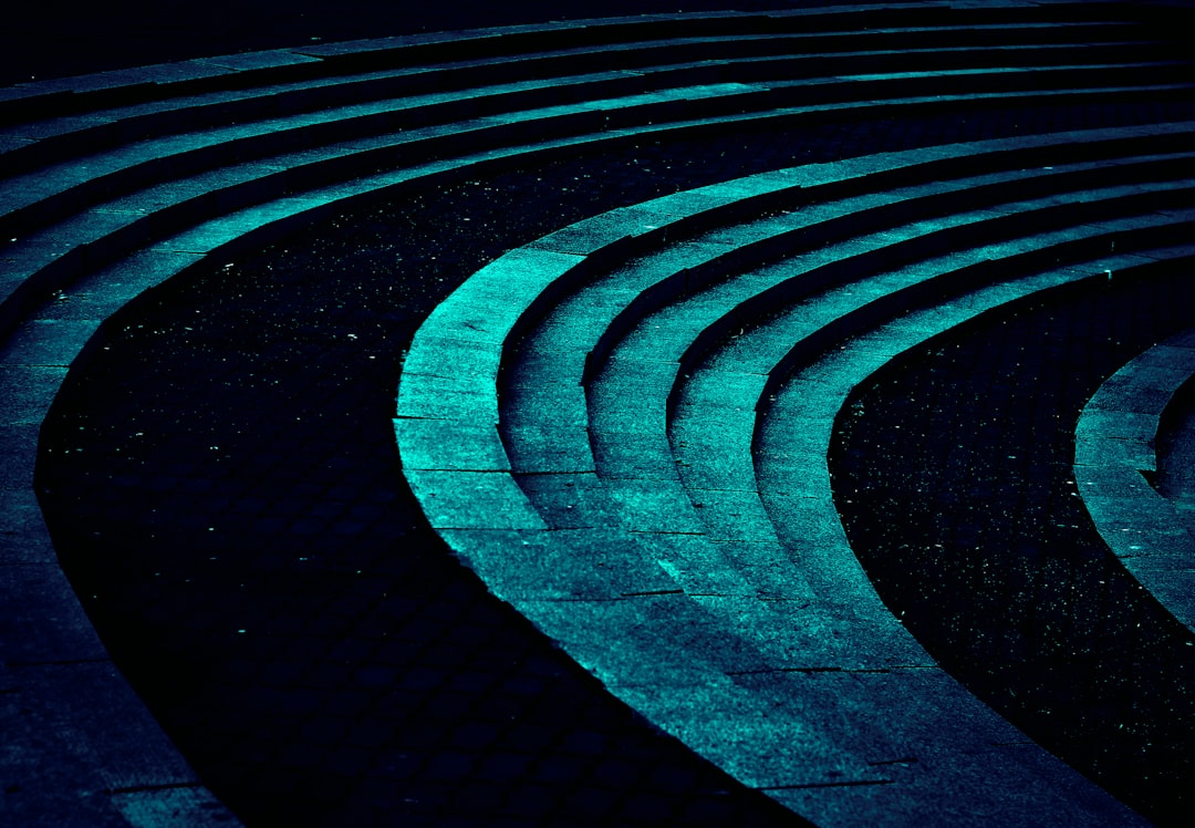 Abstract pattern of glowing turquoise curves on dark background